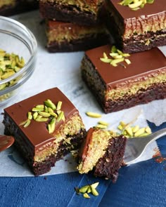 several pieces of chocolate cake with pistachios on top