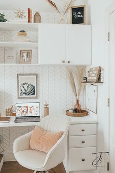 a white desk with a laptop on top of it next to a chair and shelves