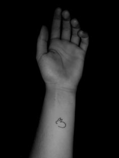 a person's hand with a small tattoo on the wrist and an apple in the middle