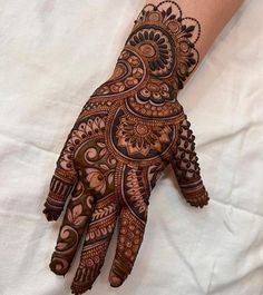 a henna on someone's hand with intricate designs