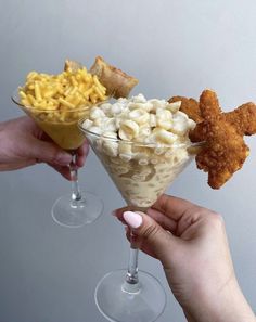 two people holding wine glasses filled with different types of food and drink in their hands