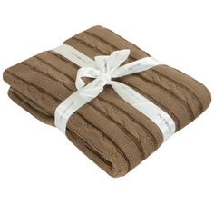 two folded brown towels with white ribbon on them