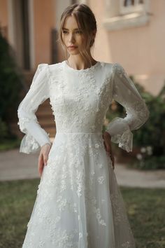 a woman in a white dress posing for the camera