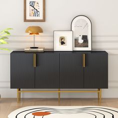 a black and gold sideboard in a white room with pictures on the wall above it