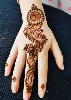 a woman's hand with henna tattoos on it