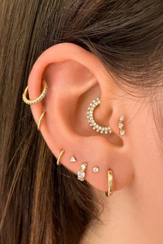 an ear with three different types of piercings on it and the words assolari written