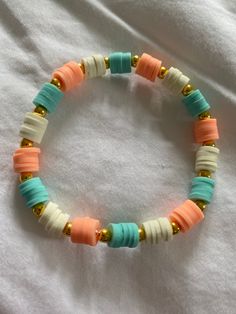 a bracelet with beads on it sitting on a bed