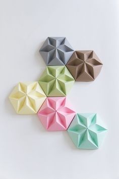 four different colored origami pieces on a white surface