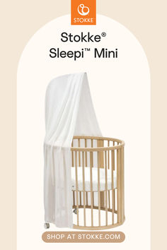 a baby crib with the cover pulled up to it's side, in front of an ad for stokke sleepi mini