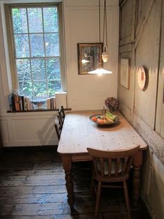 a wooden table sitting next to a window in a room