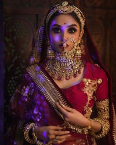 a woman in a red and gold outfit with jewelry on her neck, wearing a large necklace