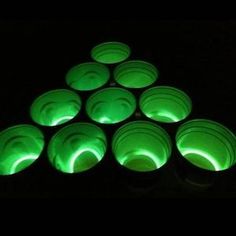 glow in the dark candles are arranged on top of each other, with green lights