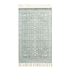 a light green rug with fringes on the bottom and an intricate design in the middle