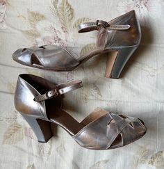 These are a great pair of Silver 1930's shoes. They have an open toe and a criss cross pattern on the front.  They're in general good condition. There is wear to the soles and a tiny tear on the front. The shoes have general wear. The silver is a little rubbed on the sides and back. There are a few small nicks in the leather.   They're a great pair of shoes and very glamorous. Interior sole length approx 25cm  Widest point of sole 8cm  Heel height 7.5cm 1930s Shoes For Women, Vintage Low Heel Shoes With Heel Loop, Vintage Heels With Low Heel And Heel Loop, Fitted Open Toe Dance Shoes, Vintage Fitted Dance Shoes With Low Heel, Fitted Vintage Dance Shoes With Low Heel, Vintage Fitted Closed Toe Dance Shoes, Vintage Low Heel Formal Sandals, Vintage Low Heel Sandals For Formal Occasions