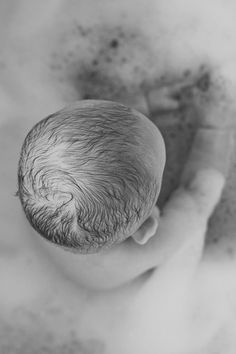 a baby is laying down in the bathtub