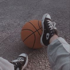 a person standing next to a basketball on the ground