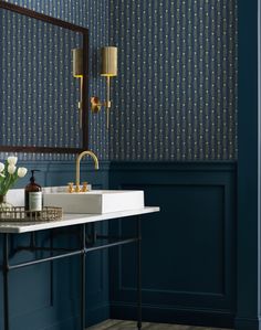 a bathroom with dark blue walls and gold accents