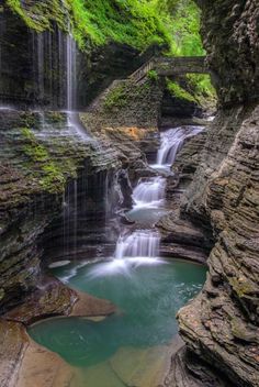 a small waterfall in the middle of a forest