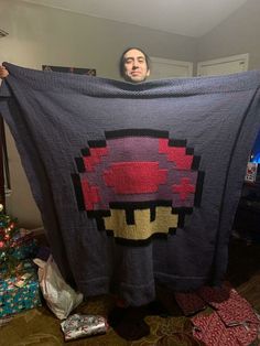 a man holding up a blanket with an image of a skull on it