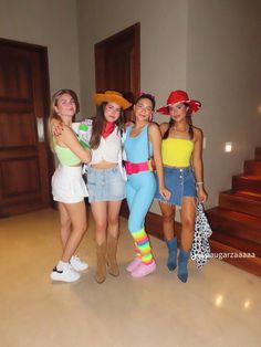 four girls are posing for the camera in front of some stairs with their hats on