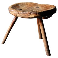 an old wooden stool with two legs and a seat made out of tree stumps