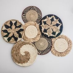 four woven baskets with black and white designs on the sides, arranged in a circle