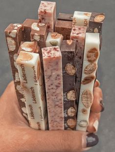 a hand holding several different types of soaps