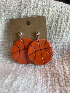 a pair of earrings with basketballs on them