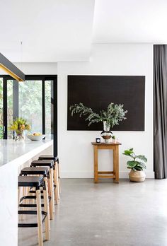 a kitchen with stools and a table in front of a painting on the wall