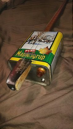 an old matchbox with matches and a baseball bat laying on a bed covered in brown sheets