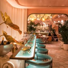 a long table with blue chairs and plants on it