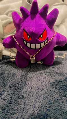 a purple stuffed animal sitting on top of a bed