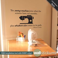 the sewing machine wall decal is next to a table with scissors and other crafting supplies