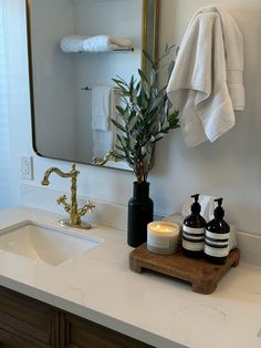 a bathroom sink with two bottles on it and a towel hanging over the counter next to it