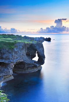 an image of the ocean and cliffs at sunset