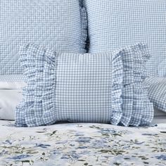 the blue and white bedding has ruffles on it's sides, along with pillows