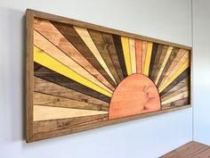 a wooden wall hanging on the side of a white wall