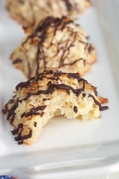 three cookies with chocolate drizzled on them sitting on a white platter