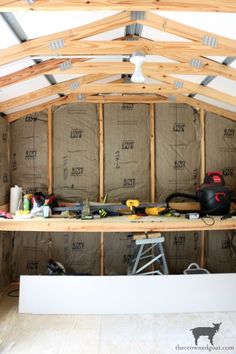 an unfinished room with wood framing on the ceiling and insulation in place for walls to be built