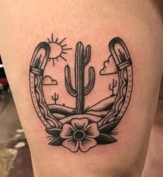 a black and white photo of a cactus tattoo on the side of a woman's thigh