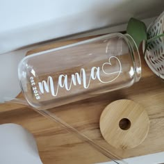 a glass bottle with the word mama written on it sitting next to a cutting board