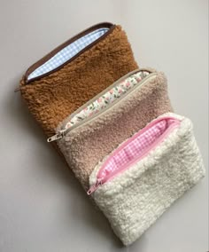 three zippered pouches sitting next to each other on top of a white table