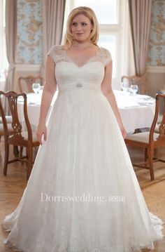 a woman standing in front of a table wearing a wedding dress