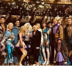 a group of people dressed in costumes posing for a photo with one man and two women