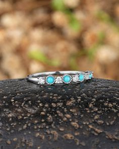 three stone ring sitting on top of a rock