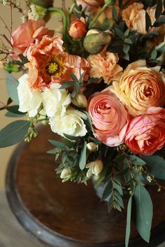 a vase filled with lots of flowers on top of a table