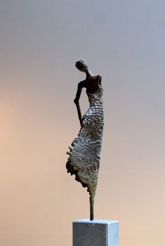 a bronze statue is standing on a pedestal