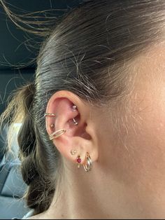 a close up of a person with ear piercings on their ears and in the back seat of a car