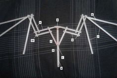 the top part of a black shirt with white lines on it and arrows pointing in different directions