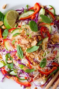 a white plate topped with salad and chopsticks